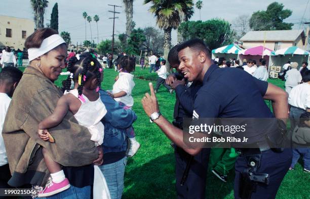 Los Angeles Police Department Officer Robert Rivers talks with Virginia Davis and daughter Crystal during Martin Luther King Parade and celebration...