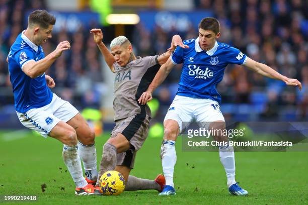 James Tarkowski and Vitaliy Mykolenko of Everton in action with Richarlison of Tottenham Hotspur during the Premier League match between Everton FC...