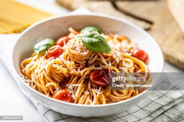 plate with spaghetti in tomato sauce, parmesan cheese and basil. - massa alimento básico imagens e fotografias de stock