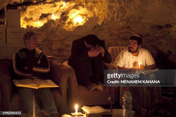 Kabbalist Rabi Uri Revach crouches on his seat next to his students during overnight Kabbalah studies inside a Jerusalem mountain cave near the...