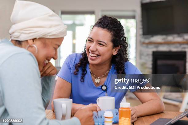 while talking about meds, female nurse and female patient laugh - nurses laughing stock pictures, royalty-free photos & images
