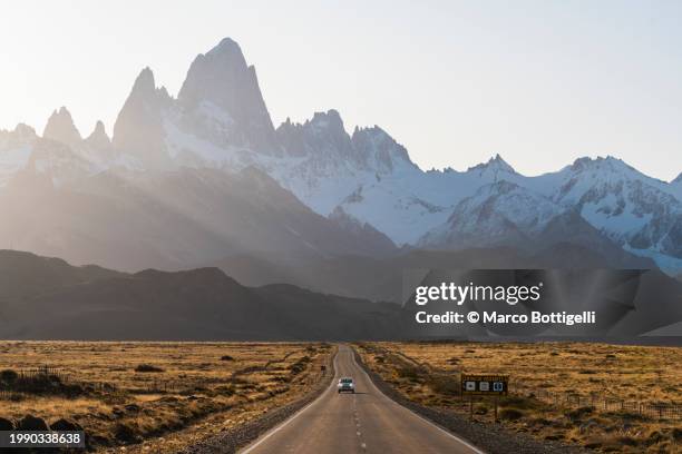 car driving at sunset with mount fitz roy in the background, patagonia, argentina. - santa cruz province argentina stock pictures, royalty-free photos & images