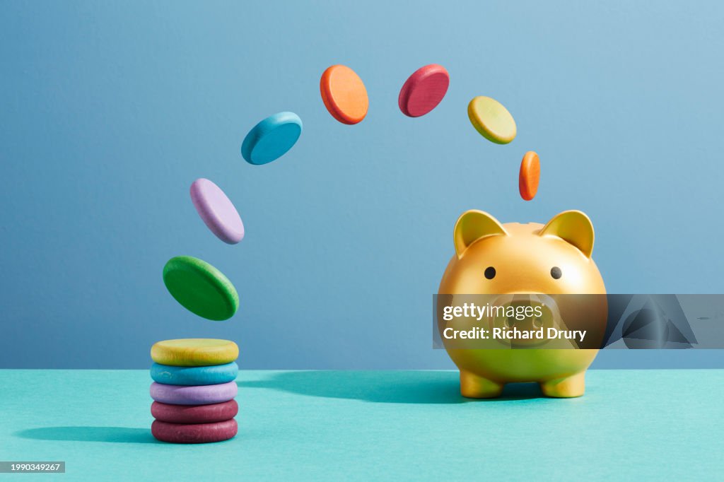 Coins moving from a stack into a piggy bank