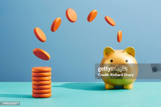 a piggy bank filling up with coins - financial planning stock pictures, royalty-free photos & images