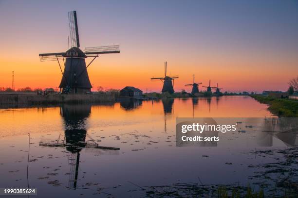 group of traditional windmills at sunrise, kinderdijk, the netherlands a world heritage site. - kinderdijk stock pictures, royalty-free photos & images