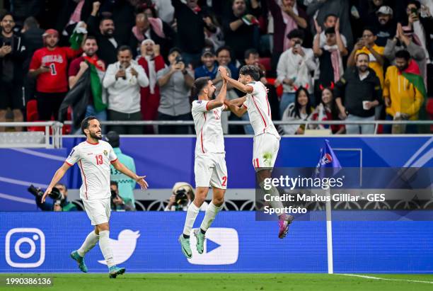 Yazan Al-Naimat of Jordan celebrates after scoring his team's first goal with Nizar Al-Rashdan during the AFC Asian Cup semi final match between...