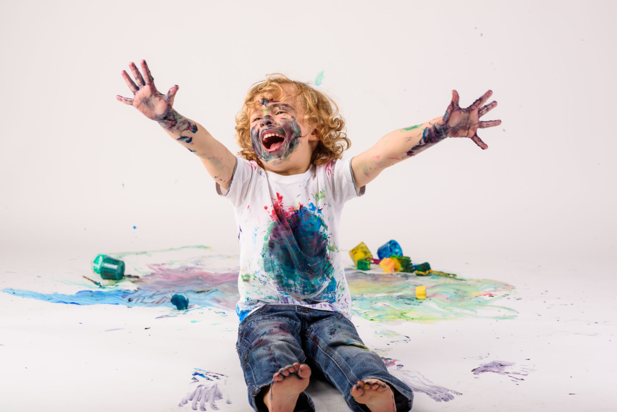 Excited boy covered with paints in studio Excited boy covered with paints in studio