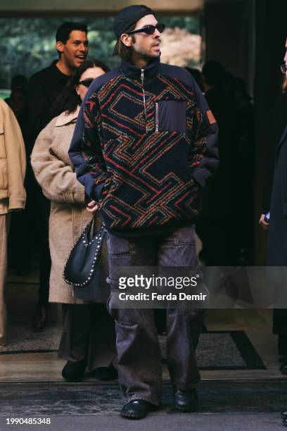 Guest wears Tommy Hilfiger Quarter Zip Sweatshirt in Polar-fleece and denim cargo pocket outside Giorgio Armani show during the Milan Fashion Week -...