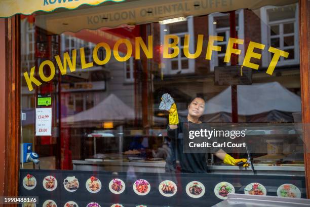 Woman cleans a restaurant window in Chinatown on February 9, 2024 in London, England. Chinese New Year, also known as Lunar New Year, falls on...