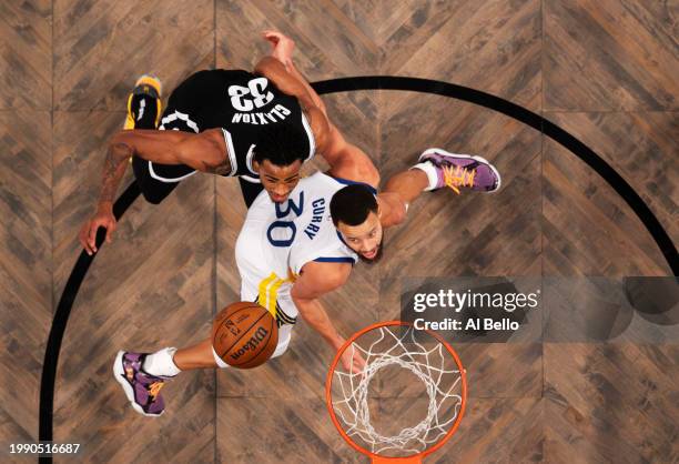 Stephen Curry of the Golden State Warriors and Nic Claxton of the Brooklyn Nets battle for the ball during their game at Barclays Center on February...