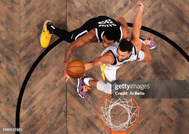 Stephen Curry of the Golden State Warriors and Nic Claxton of the Brooklyn Nets battle for the ball during their game at Barclays Center on February...