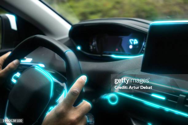 driving a futuristic car interior with glowing blue light. - coche del futuro fotografías e imágenes de stock