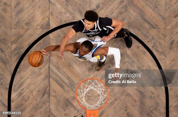 Jonathan Kuminga of the Golden State Warriors and Cameron Johnson of the Brooklyn Nets battle for the ball during their game at Barclays Center on...