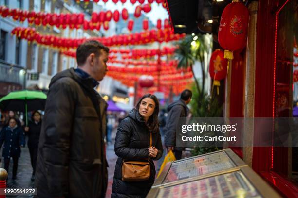 Couple browse a restaurant menu in Chinatown on February 9, 2024 in London, England. Chinese New Year, also known as Lunar New Year, falls on...