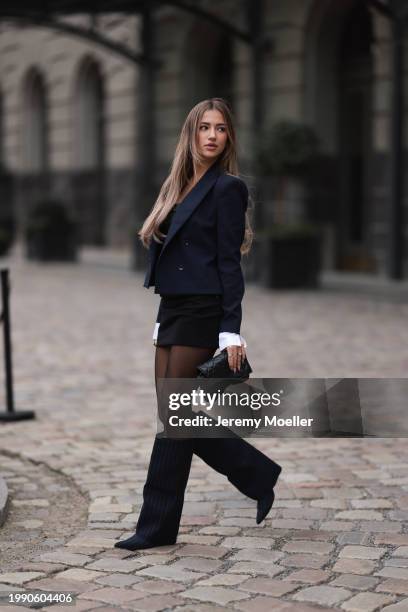 Joelle Marie Jaracz seen wearing navy blue short blazer jacket, black belted bandeau sleeveless short dress, black tights, black leather bag, gold...