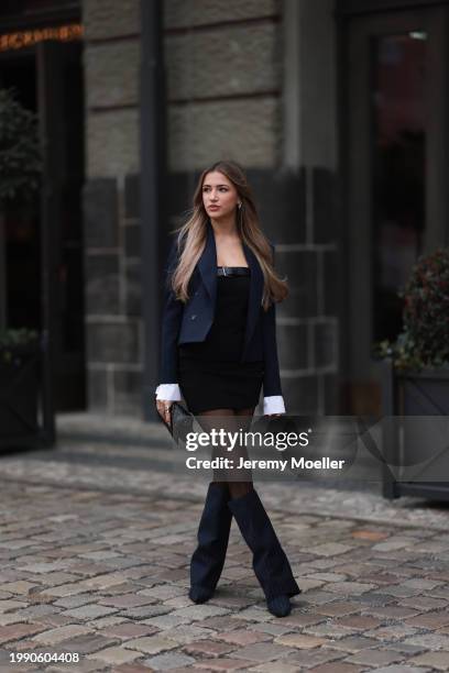 Joelle Marie Jaracz seen wearing navy blue short blazer jacket, black belted bandeau sleeveless short dress, black tights, black leather bag, gold...