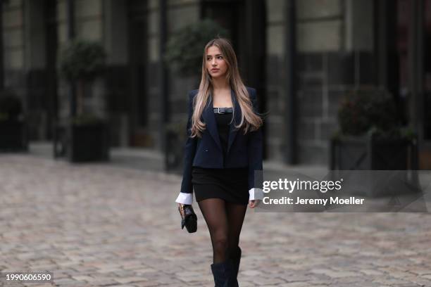 Joelle Marie Jaracz seen wearing navy blue short blazer jacket, black belted bandeau sleeveless short dress, black tights, black leather bag, gold...