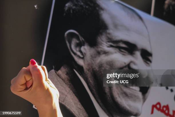 Tunisians lift placards while shouting slogans as they demonstrate in commemoration of the 11th anniversary of the assassination of prominent leftist...