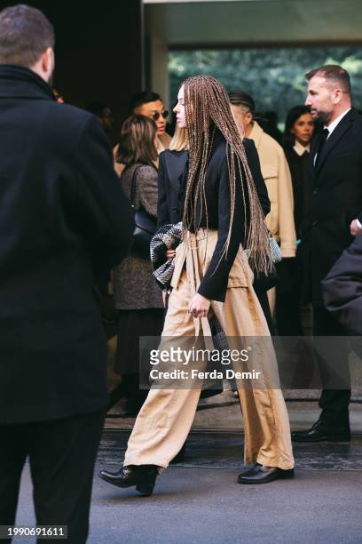 Guest wears knit long hair, black sweater, choco tied pants outside Giorgio Armani show during the Milan Fashion Week - Menswear Fall/Winter...