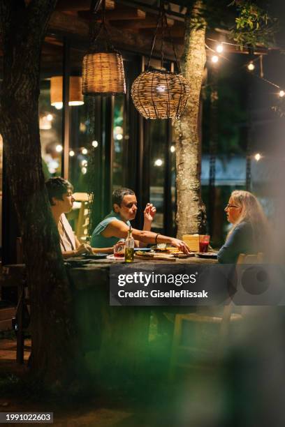 mature women eating pizza for dinner on a restaurant patio - café esplanada imagens e fotografias de stock
