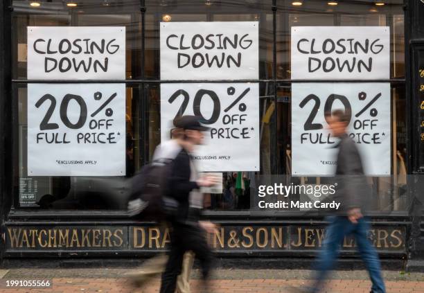 People walk past a shop unit that is closing down on the high street in Taunton, on November 22, 2023 in Somerset, England. Business for some high...