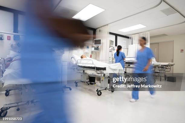 doctors and nurses pulling hospital trolley - emergency room doctors pushing patient on gurney blurred motion stock pictures, royalty-free photos & images