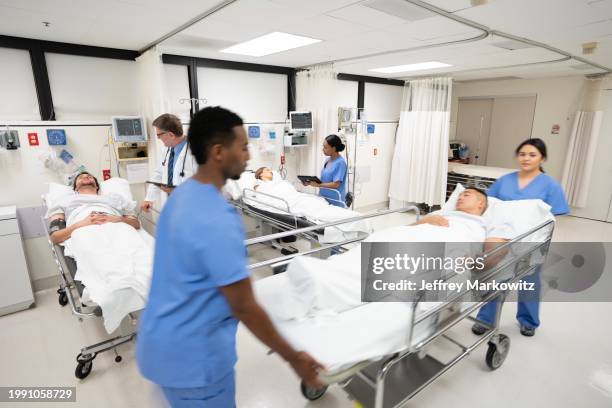 doctors and nurses pulling hospital trolley - emergency room doctors pushing patient on gurney blurred motion stock pictures, royalty-free photos & images