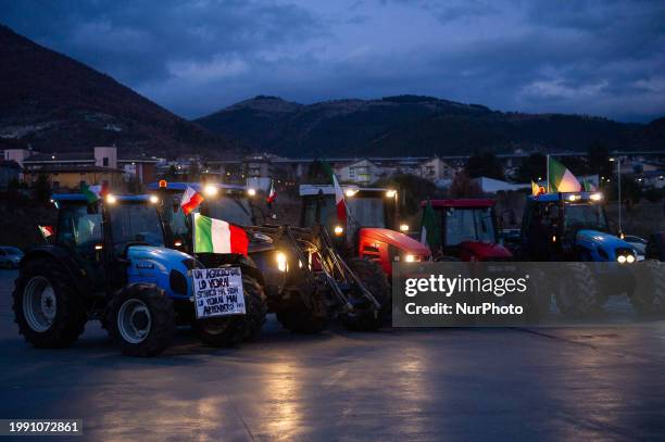 Banner reading "you'll see a farmer tired but never giving up" on parked tractors is seen during a farmers protest in L'Aquila, Italy, on February...