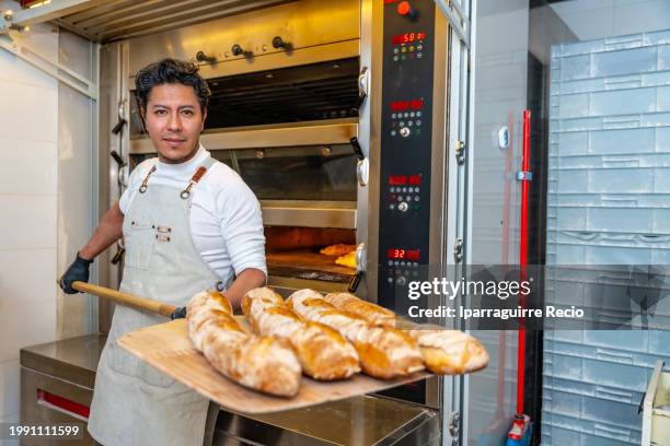 baker showing proud freshly made bread holding a peel - pá de pizza imagens e fotografias de stock