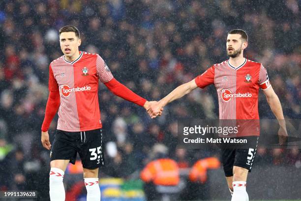 Jan Bednarekof Southampton holds hands with Jack Stephens during the Emirates FA Cup Fourth Round Replay match between Southampton and Watford at St...
