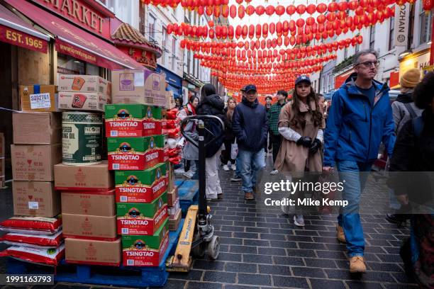 Pallets of food and Tsingtao beer are dealt with as people stock up on Gerrard Street in Chinatown as newly installed red lanterns hang above in...