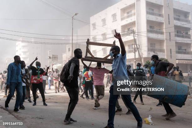 Protesters shout slogans and collect barrels and tables to burn during clashes with police on the sidelines of a protest against a last-minute delay...