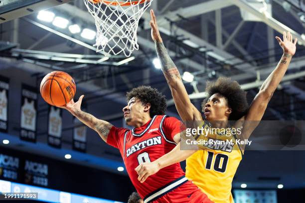 Javon Bennett of the Dayton Flyers shoots past Toibu Lawal of the VCU Rams in the first half during a game at Siegel Center on February 9, 2024 in...