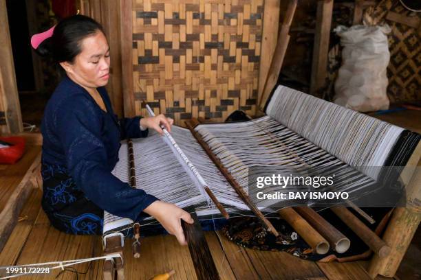 This picture taken on January 25, 2024 shows a member of the Indigenous Baduy tribe using a traditional weaving machine in Kanekes Village in Lebak,...