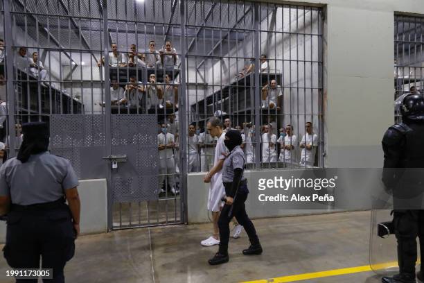 An inmate is escorted by a guard at CECOT in Tecoluca on February 6, 2024 in San Vicente, El Salvador. On February of 2023 El Salvador inaugurated...