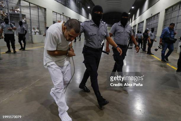 An inmate is escorted by a guard at CECOT in Tecoluca on February 6, 2024 in San Vicente, El Salvador. On February of 2023 El Salvador inaugurated...