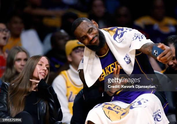 LeBron James of the Los Angeles Lakers takes a selfie on the bench during the second half of the game against New Orleans Pelicans at Crypto.com...