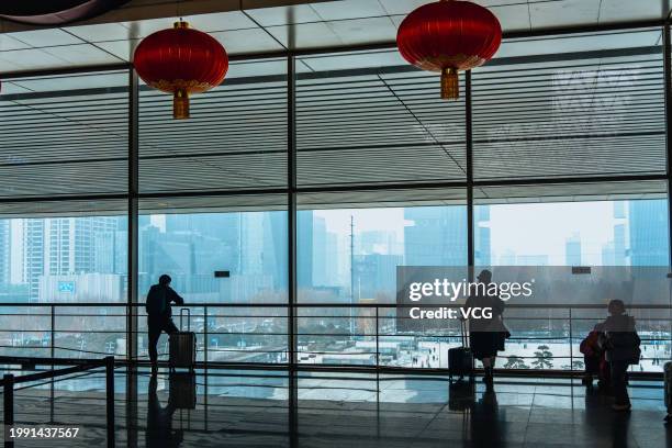 Travels enjoy a view from the window at the waiting hall of Zhengzhou East Railway Station during the Spring Festival travel rush on February 6, 2024...