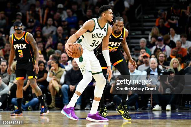 Giannis Antetokounmpo of the Milwaukee Bucks controls the ball against Kevin Durant of the Phoenix Suns during the first half of the game at...