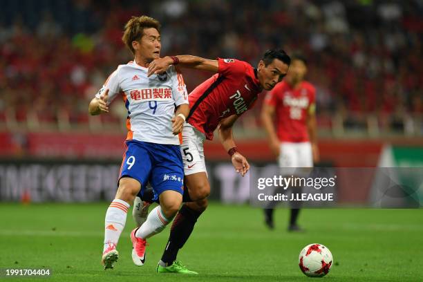 Tomoaki Makino of Urawa Red Diamonds controls the ball against Ryohei Yamazaki of Albirex Niigata during the J.League J1 match between Urawa Red...