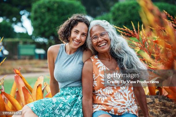 loving mother and adult daughter enjoying time together outdoors - aziatische etniciteit stockfoto's en -beelden