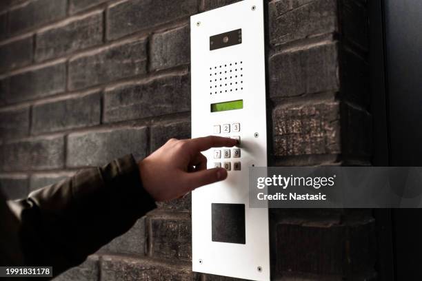 young man using intercom to call - audio intercom system stock pictures, royalty-free photos & images