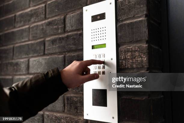 young man using intercom to call - bell telephone company stock pictures, royalty-free photos & images