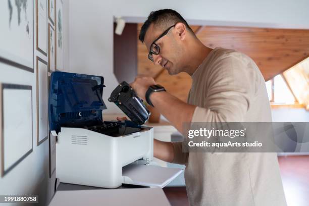 l’homme change le toner de l’imprimante à la maison - imprimante photos et images de collection