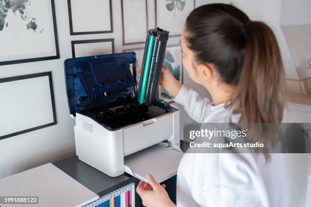 woman change the printer toner at home - fotokopieerapparaat stockfoto's en -beelden