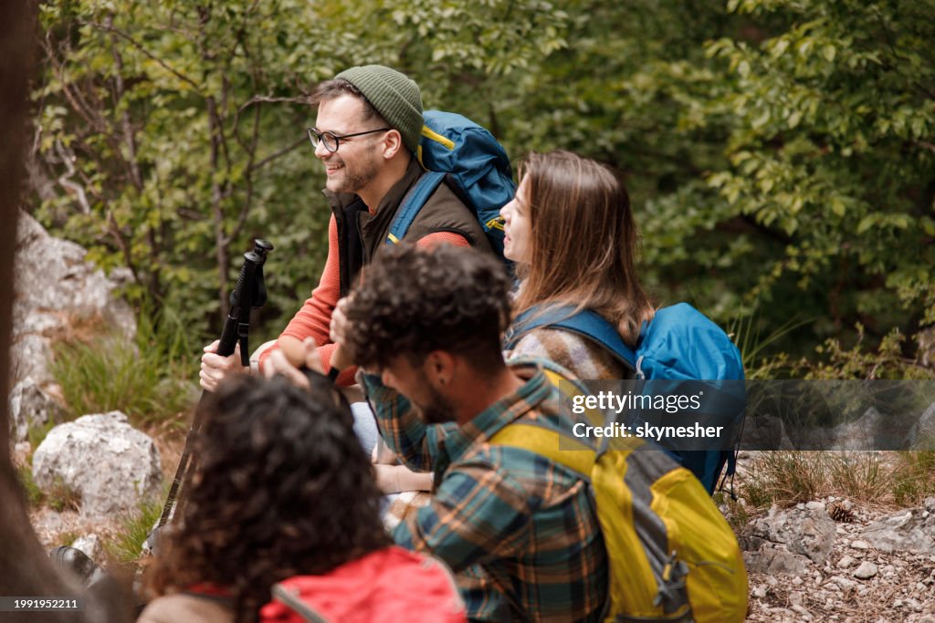 Group of happy hikers enjoying on rocky mountain.
