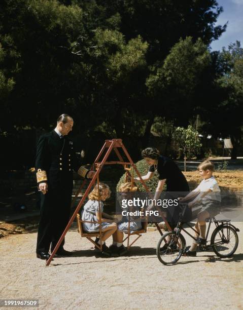 Greek Royals Paul of Greece, in naval uniform, his daughters, Princess Sophia of Greece and Denmark with Princess Irene of Greece and Denmark on a...