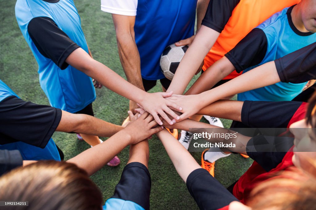 Equipe de futebol juvenil United mãos no futebol antes do jogo