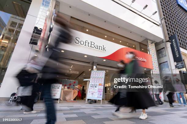 Pedestrians walk past a SoftBank branch on February 07, 2024 in Tokyo, Japan. SoftBank Group Corp. Is a Japanese multinational holding company that...