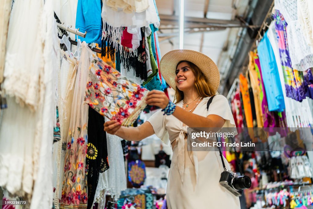 Young woman looking clothes at market